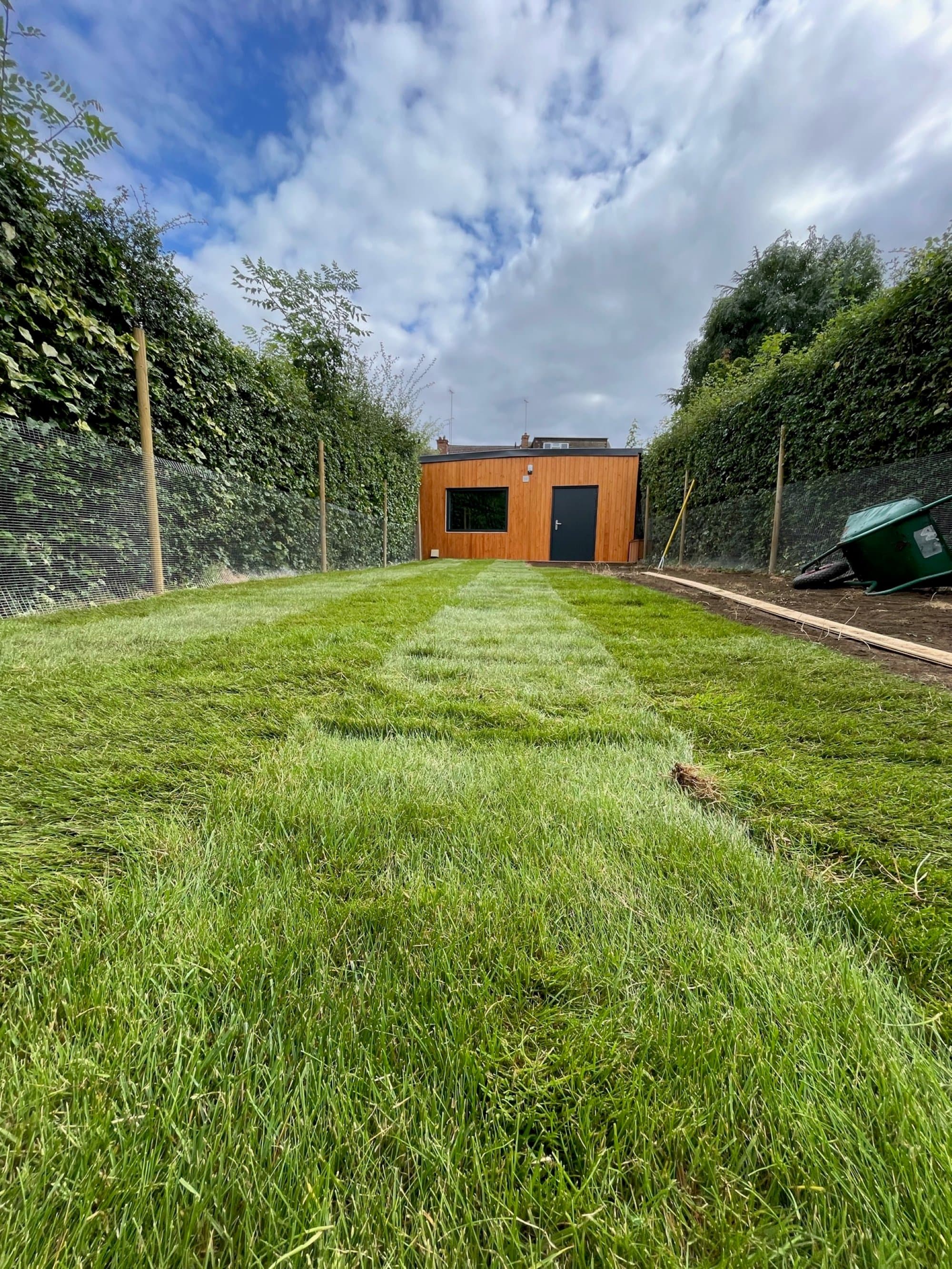 A wider view of the freshly laid turf running down the full length of the garden